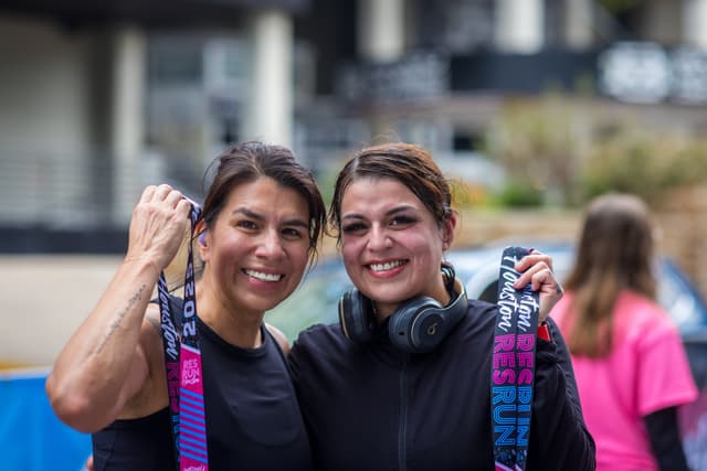 Two runners with their finisher medals
