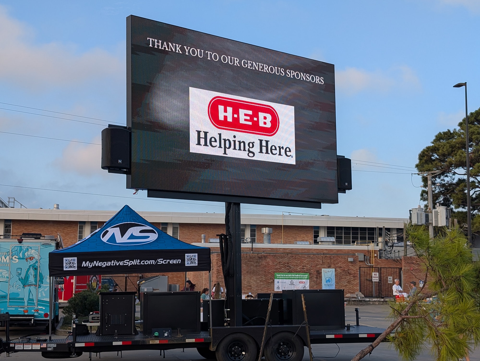 The screen running a sponsor thank you slide in daylight